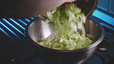 un tazón forrado con un aderezo donde se agregan repollo y pimientos para una ensalada de pollo baja en calorías