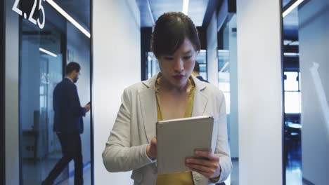 Mujer-De-Negocios-Trabajando-Mientras-Camina-En-Una-Oficina-Moderna