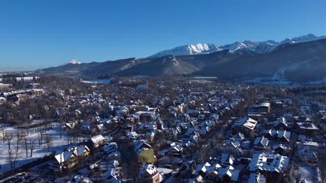 Vista-Aérea-De-La-Hermosa-Zakopane-En-Polonia,-En-Invierno-En-La-Nieve-Con-Las-Montañas-Tatra-En-El-Fondo