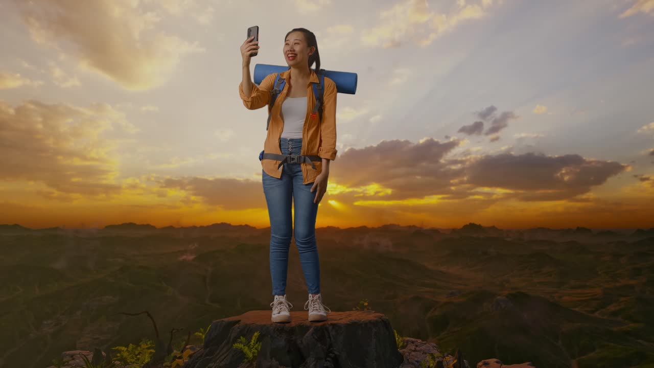 mujer tomando una selfie en la cima de una montaña al atardecer