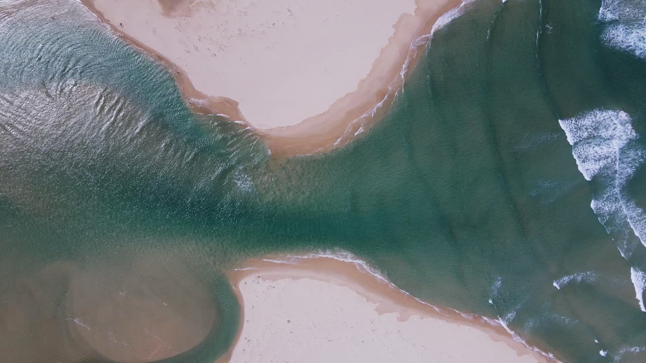 la apertura de una desembocadura de la laguna al océano a medida que la marea fluye en