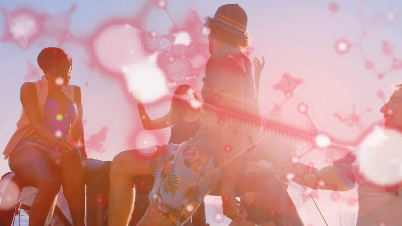 Five friends sitting on truck bed at shoreline, woman raising hand starting pink bokeh for travel