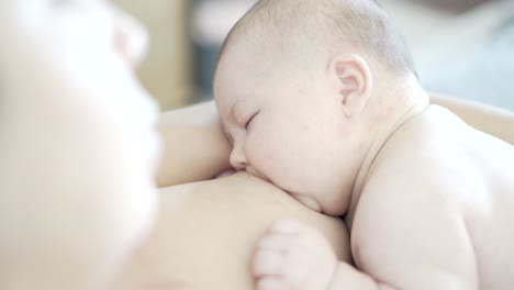Mother-breastfeeds-her-two-month-old-newborn-baby,-that-is-almost-sleeping-and-fixes-his-latching-mouth-position-before-the-baby-pulls-away