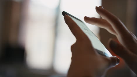 Close up of womans hands using smart phone technology to read architectural plans