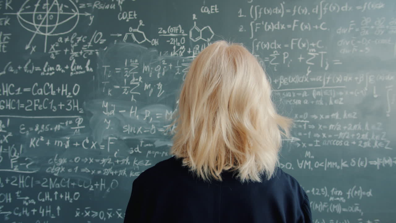 Woman looking at complex equations on a chalkboard