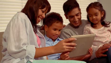 Familia-Hispana-Sonriente-En-Una-Tableta