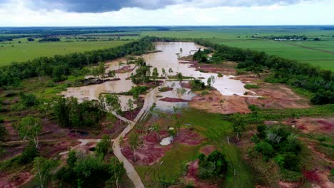 vuelo esenic sobre mina de arcilla roja, ver agua turbia, vegetación y montañas, república dominicana