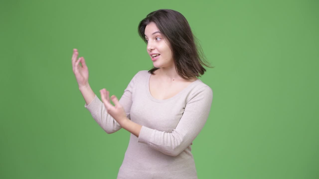 Wanita muda cantik mempresentasikan sesuatu