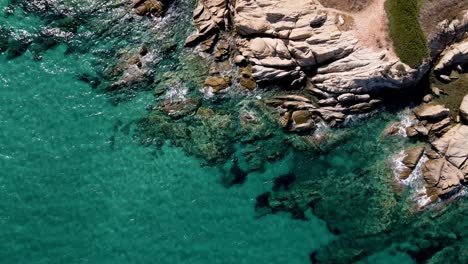 Steady-Aerial-drone-clip-over-a-rock-formation-in-an-exotic-beach-in-Vourvourou,-Chalkidiki,-Greece