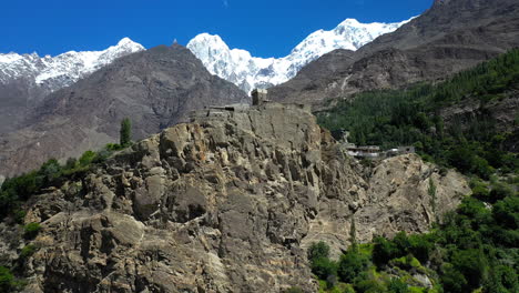 Drone-shot-of-an-old-structure-or-fort-on-Karakoram-Highway-Pakistan-with-the-passu-cones-in-the-distance