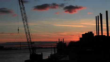 the sun sets as the clouds pass over a factory region near detroit michigan