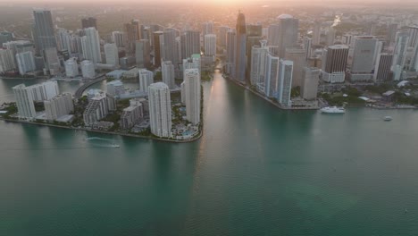 high angle view of high rise buildings on waterfront. tilt up reveal modern urban borough against setting sun. miami, usa