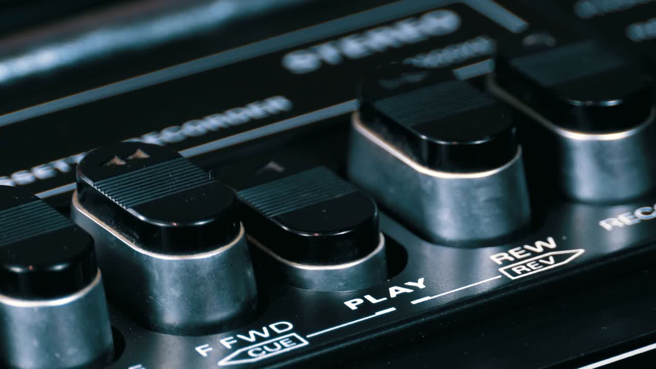 presionando el botón de un grabador de cinta, jugar, detener, grabar, ff, rew