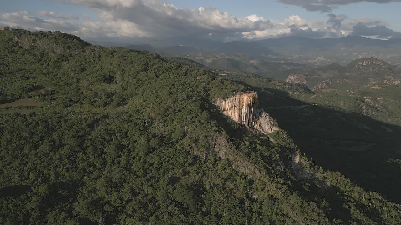 una puesta de sol dorada brilla sobre los turistas que visitan el enorme acantilado de flowstone, méxico