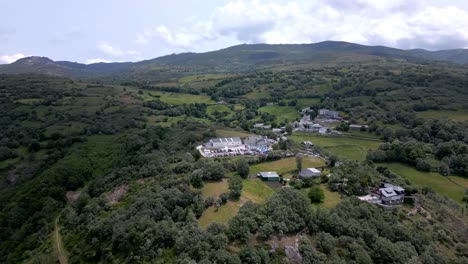 Aerial-drone-footage-overlooking-a-small-cluster-of-buildings-in-a-beautiful-mountain-range