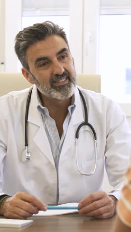 confident male doctor talking to patient in clinic during daytime
