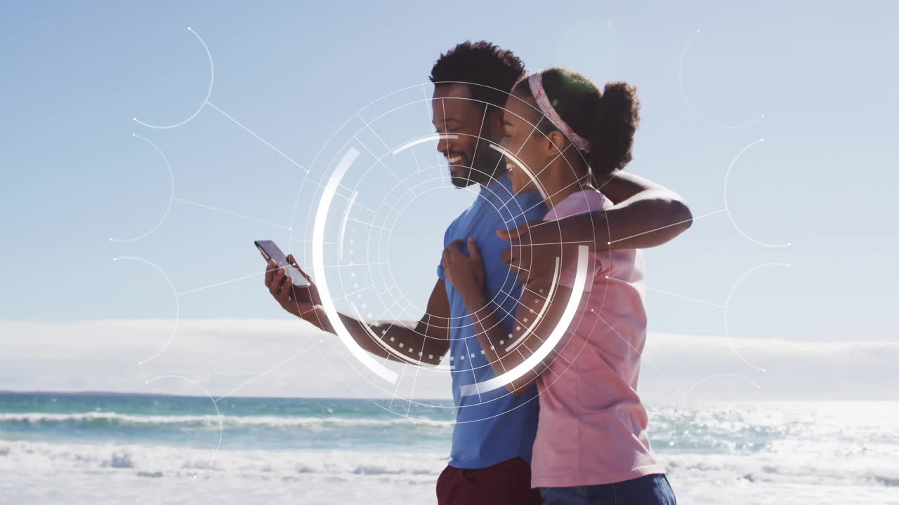 Couple on beach with smartphone, digital interface animation over them