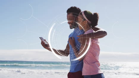 couple on beach with smartphone, digital interface animation over them