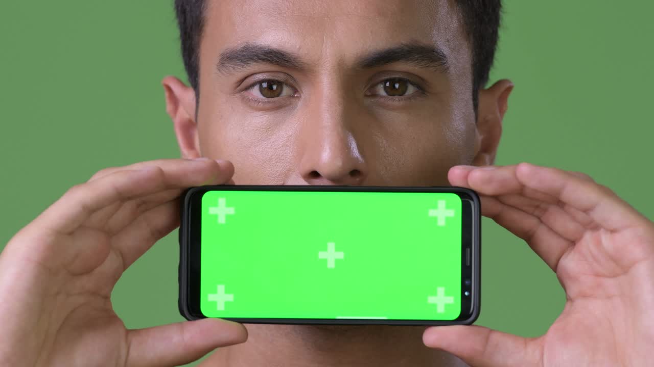 초록색 배경에 젊은 잘생긴 히스패닉 남자