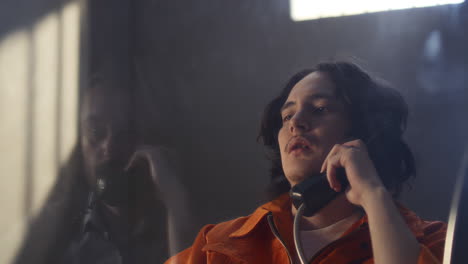 inmate talking on phone during interrogation in prison visitation room