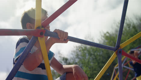 Schoolboy-climbing-on-dome-climber-in-playground