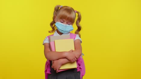 Unhealthy-little-schoolgirl-kid-wearing-protective-medical-mask,-standing-with-books-looking-tired