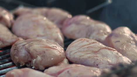 Close-up-raw-chicken-fillet-roasting-on-grill-outdoor.-Gilling-turkey-breasts.