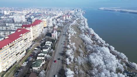 conducción panorámica en carretera de asfalto a través del paisaje urbano y los árboles de invierno junto al río danubio