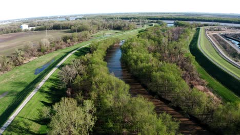 Drohnenaufnahme-Eines-Schmutzigen-Schlammigen-Baches-Mit-Vielen-Bäumen-Und-Viel-Grün-In-Einer-Kleinen-Stadt-Am-Mississippi