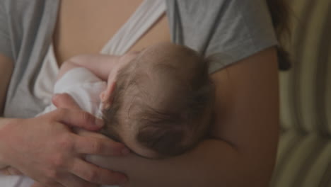 madre sosteniendo a un bebé dormido