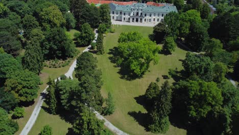 Aerial-Drone-Shot-of-a-big-Park-revealing-a-historic-Palace-in-Vienna