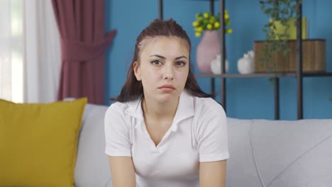 una mujer joven mirando pensativa a la cámara.