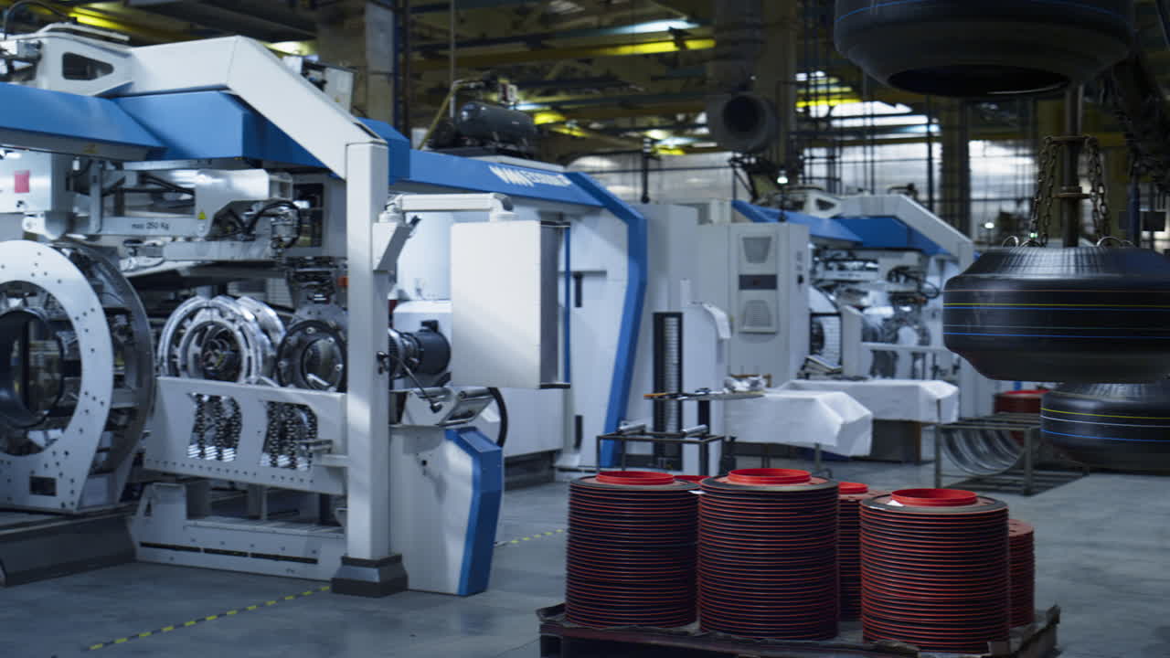 modernas máquinas tecnológicas de almacenamiento de la fábrica de neumáticos con trabajador de fondo