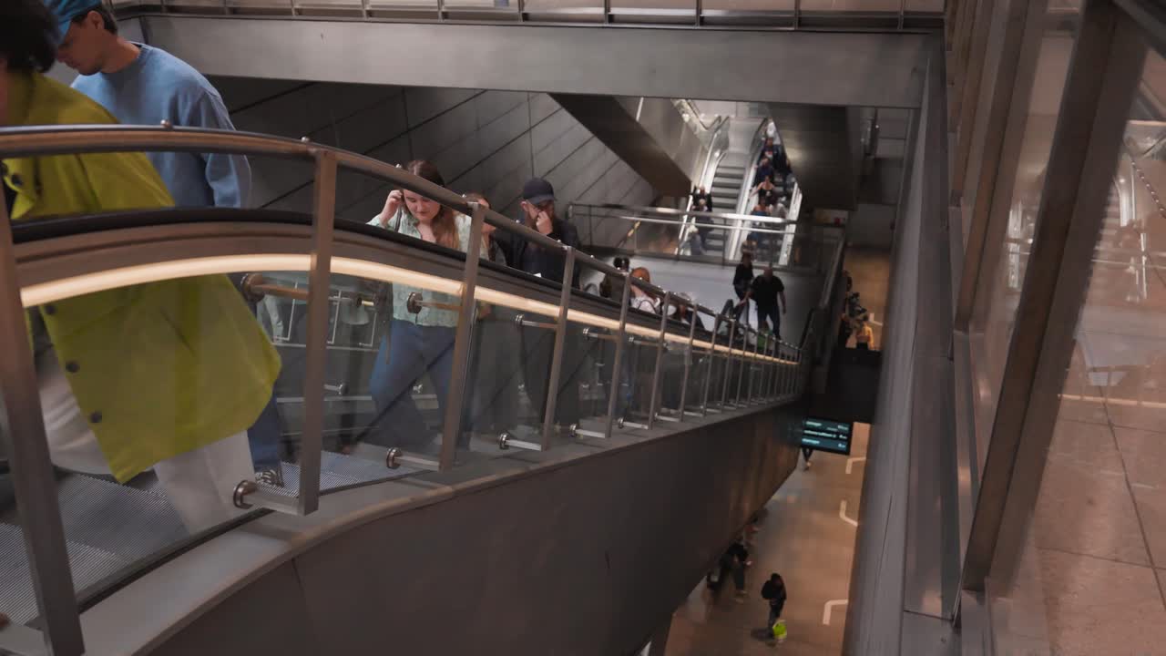 People Riding Escalator in Modern Subway Station