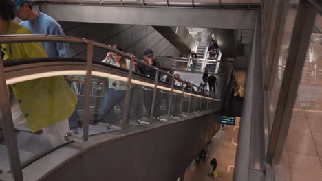 People Riding Escalator in Modern Subway Station