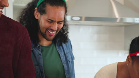 at christmas, diverse friends laughing together in kitchen during festive holiday gathering at home