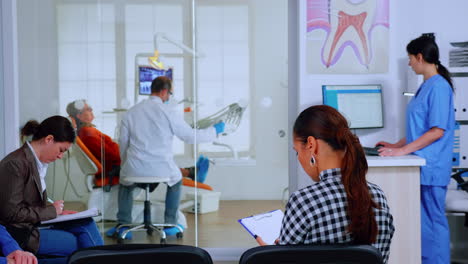 back view of woman filling in dental document sitting on chiar