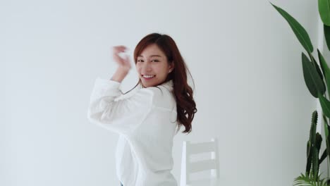 slow motion lovely asian woman happy dancing with glad emotion and smiling in the white room