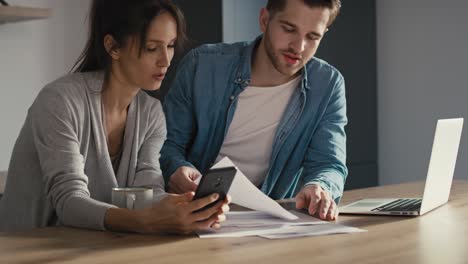 miserable young caucasian couple having financial problems due to new house.