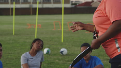 young adult female rugby team training with coach