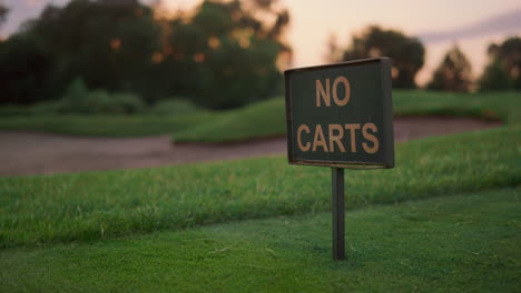 golf course grass sign in empty grass fairway. transport restriction in field.