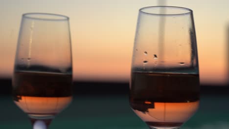a glass of champagne with a beautiful sunset view behind