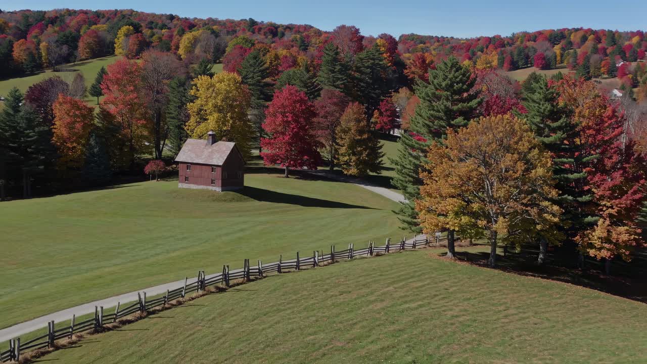 Aerial video captures a rustic cabin amidst vibrant autumn foliage