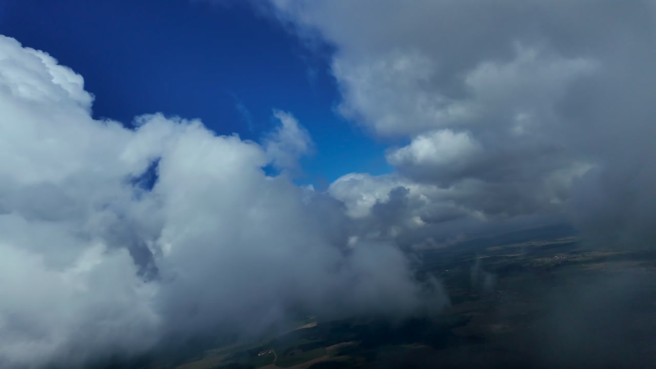 Hyperlapse taken from an airplane cockpit flying through broken small cumulus clouds in a blue sky dong some turns.