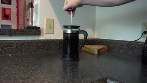 una cafetera de prensa francesa preparando una taza de café recién hecho