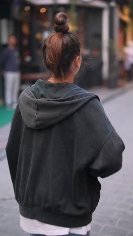 una mujer joven caminando por la ciudad.