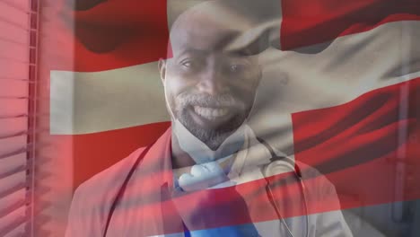 Animation-of-flag-of-switzerland-waving-over-african-american-doctor-wearing-face-mask