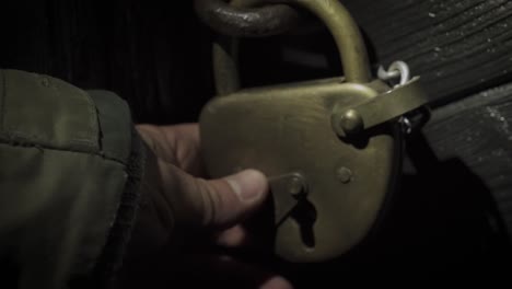 hand opening door with vintage padlock at night. norwegian trekking association. - closeup shot