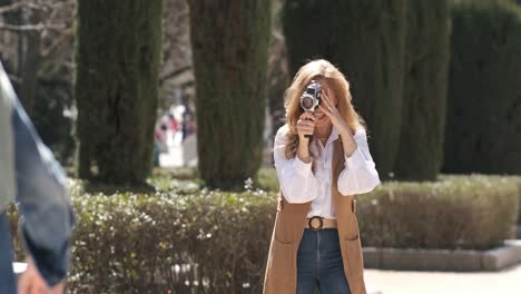 mature woman recording a video with friends in a park