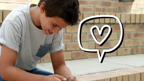 icono del corazón en la burbuja de habla contra el niño que usa el teléfono inteligente al aire libre